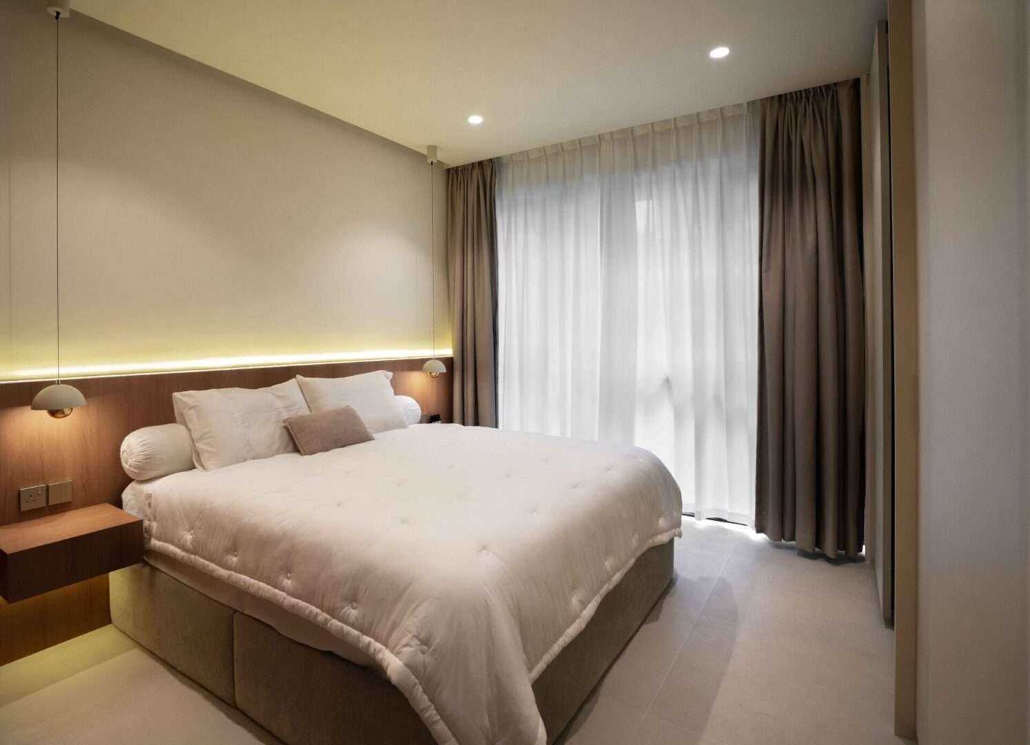 Cozy master bedroom with cove lighting and full-height curtains