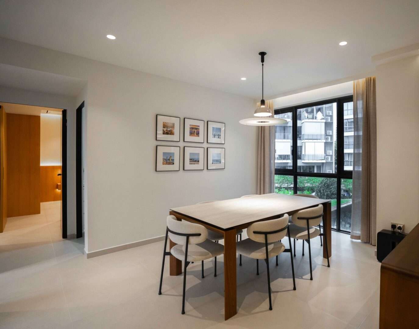 Dining area with wood table, pendant light and large window